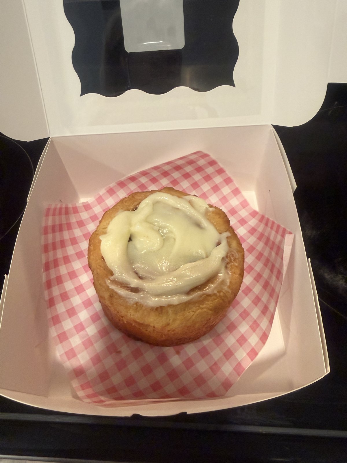 One Nana Bun, frosted by hand, on pink gingham